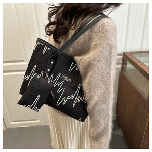 Detailansicht der schwarzen Tote Bag mit Wellenmuster und passender Anhänger-Tasche