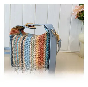 Détail du tissage en paille multicolore et des crochets de la bandoulière en cuir bleu