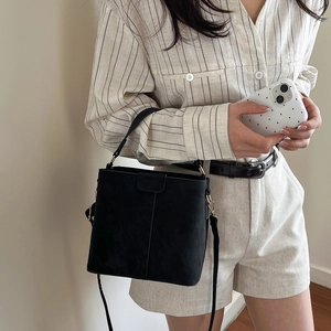 Retro black matte bucket bag with gold hardware and adjustable crossbody strap