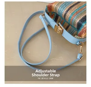 Gros plan sur la bandoulière réglable en cuir bleu clair d'un sac en paille rayé