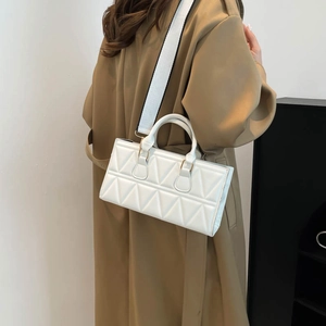 Minimalist white quilted crossbody bag with wide shoulder strap and top handles