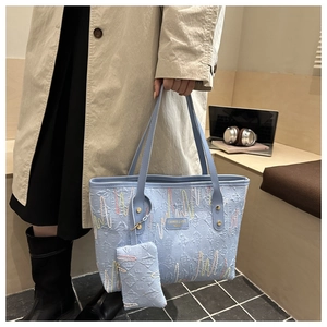 Detail der hellblauen Tote Bag mit bunter Wellenstickerei und kleiner Zusatztasche