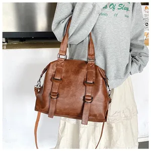 Brown vintage PU leather tote bag with dual handles and metal buckle details on a model