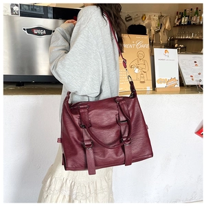 Detail of dark wine red large PU leather tote bag with soft texture and metal rings