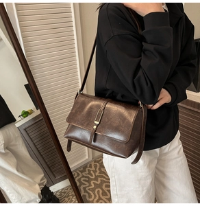 Détail d'un sac à bandoulière en cuir marron foncé vintage avec boucle en métal doré