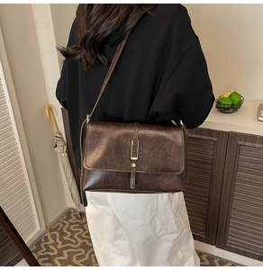 Détail du sac à bandoulière marron vintage avec fermoir doré et texture cuir premium