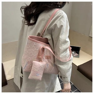 Detail der rosa Tragetasche mit Markenlogo und passender Mini-Tasche an der Schulter