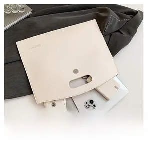 Detail view of beige lychee leather tote capacity showing tablet and phone inside