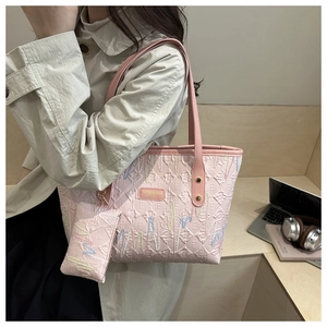 Detailansicht einer rosa gesteppten Shopper-Tasche mit passender kleiner Geldbörse am Gurt