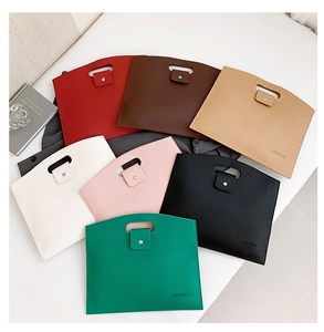 Flat lay of envelope style laptop clutch bags in seven colors with pebble grain leather