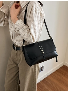 Gros plan d'un sac bandoulière vintage en cuir noir avec un fermoir métallique doré