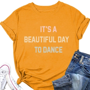 Flat lay of an orange T-shirt with IT'S A BEAUTIFUL DAY TO DANCE text print