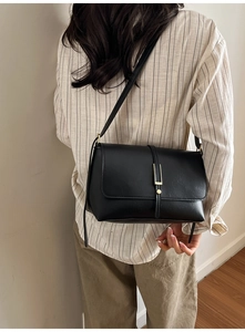 Photo lifestyle d'un sac à bandoulière en cuir noir avec boucle dorée de style français