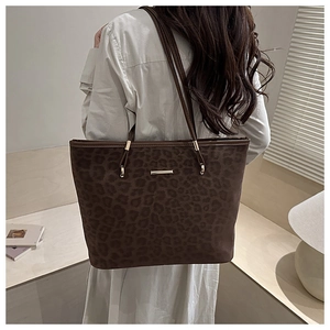 Detailed close-up of brown leopard print tote bag with premium gold hardware and texture