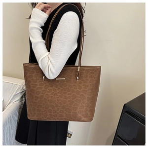 Detail of vintage leopard print tote bag in brown faux leather with metal accent