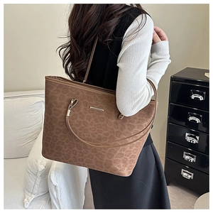 Detailed shot of leopard print tote bag with brown suede texture and slim shoulder straps