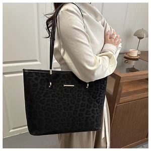 Close-up of leopard print texture and golden hardware on the black commuter tote bag
