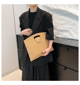 Détail du sac à main en cuir grainé fauve avec poignée découpée et fermoir aimanté