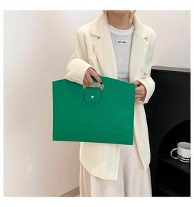 Detail of lime green pebble leather handbag featuring oval handle and flap buckle closure