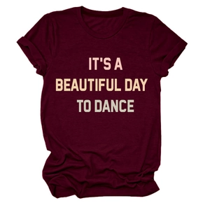Detail of burgundy T-shirt with 'IT'S A BEAUTIFUL DAY TO DANCE' printed text on fabric