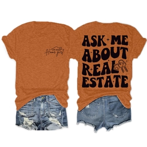 Détail du t-shirt orange avec slogan immobilier et short en jean bleu clair