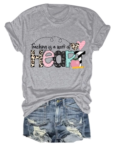 Flat lay of gray Teaching is a work of Heart t-shirt with distressed denim shorts