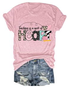 Flat lay of pink t-shirt with teaching is a work of heart print and denim shorts