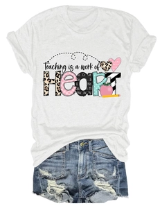 Close-up of heart and apple print on white tee with Teaching is a work of HEART text