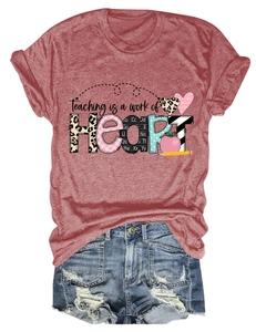 Detailed flat lay of women's brick red tee with 'Teaching is a work of Heart' art print