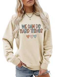 Détail du sweat crème avec slogan minimaliste We Can Do Hard Things et imprimé cœurs