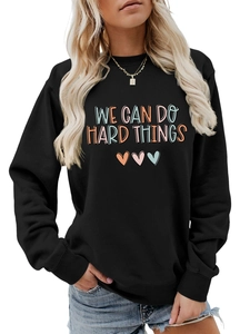 Détail d'un sweat noir en coton avec le texte motivant WE CAN DO HARD THINGS brodé