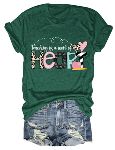 Detail of Teaching is a Work of Heart print on dark green cotton tee with denim shorts