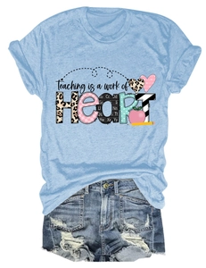 Flat lay of light blue T-shirt with heart graphic and ripped denim shorts on white background