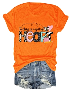 Detail of Teaching is a Work of Heart print on orange t-shirt with leopard apple motifs