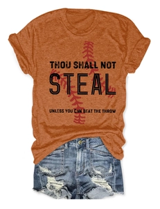 Flat lay of an orange baseball t-shirt with a slogan paired with ripped denim shorts
