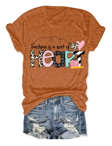 Detail of orange t-shirt with 'Teaching is a work of Heart' print and distressed denim shorts