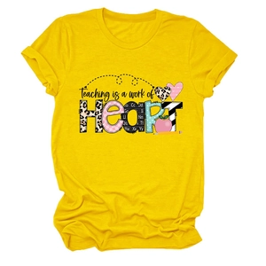 Flat lay of yellow t-shirt featuring 'Teaching is a work of HEART' text with textured patterns