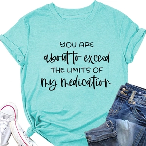 Flat lay of turquoise crewneck t-shirt with slogan, sneakers and denim jeans