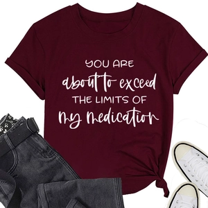 Close-up of a burgundy t-shirt featuring the printed slogan about exceeding limits