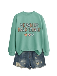Détail du sweat menthe avec imprimé cœur et ensemble de shorts en jean usé
