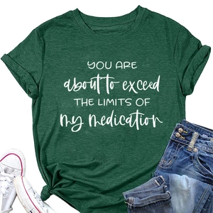 Detailed close-up of dark green t-shirt with slogan print, white shoes and jeans