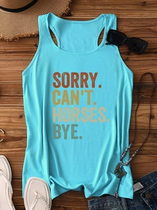 Flat lay of light blue tank top with vintage horse slogan and summer accessories on wood
