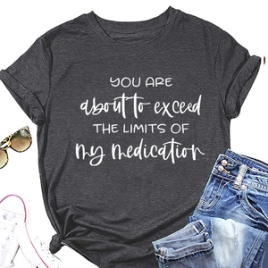 Flat lay of dark grey slogan t-shirt paired with denim shorts and sunglasses