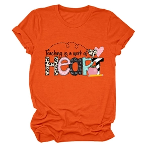 Flat lay of an orange teacher t-shirt featuring a colorful leopard print heart design