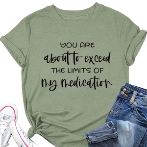 Detail of sage green crew neck tee with black funny text print and flat lay styling