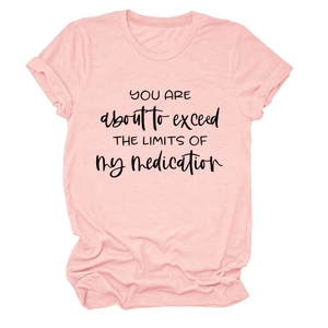 Close-up of pink round neck T-shirt with black letter print and rolled cuff detail