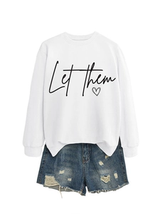 Dettaglio della scritta 'Let them' e stampa a cuore su felpa bianca con shorts di jeans
