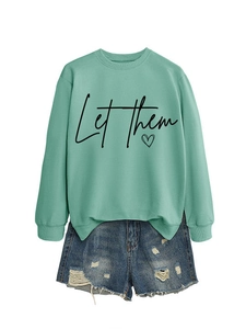 Dettaglio della felpa girocollo verde menta con stampa a cuore e shorts in denim usurati