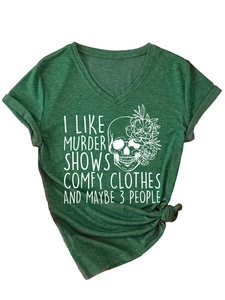 Détail du t-shirt vert foncé col V avec imprimé crâne floral et nœud sur le bas