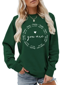 Detail der inspirierenden Aufschrift und Rippbündchen an diesem dunkelgrünen Sweatshirt